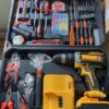 Cordless drill and hand tool kit open in its carry case, with drill, two batteries, charger, pliers, hammer and screwdrivers